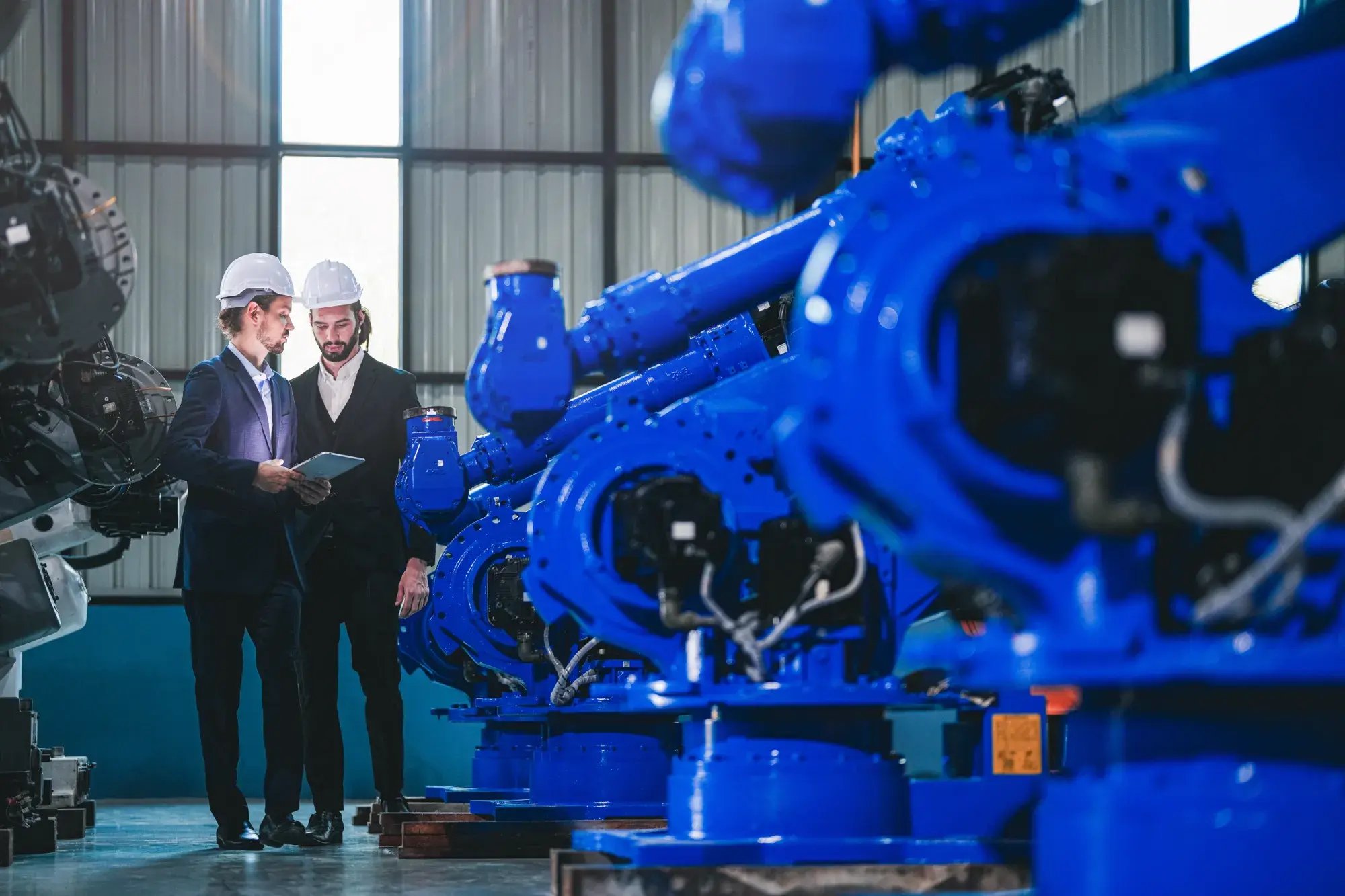 business-engineers-meet-check-control-heavy-machine-robot-arm-diverse-team-industrial-robotics-engineers-gathered-around-machine-professional-machinery-operator-use-industrial-digital-tablet