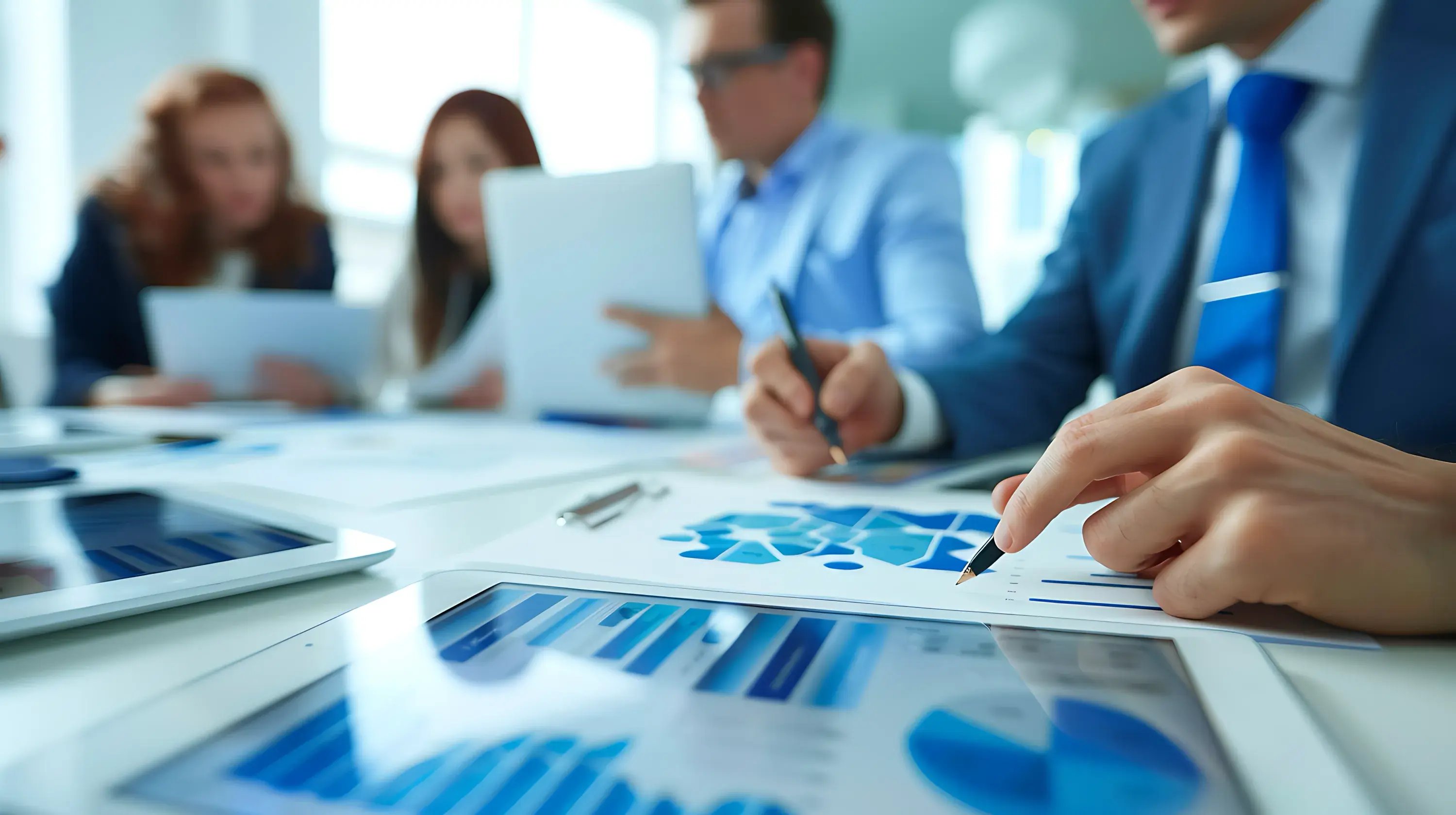 business-people-sitting-table-with-blue-graph-man-background-with-other-people-i