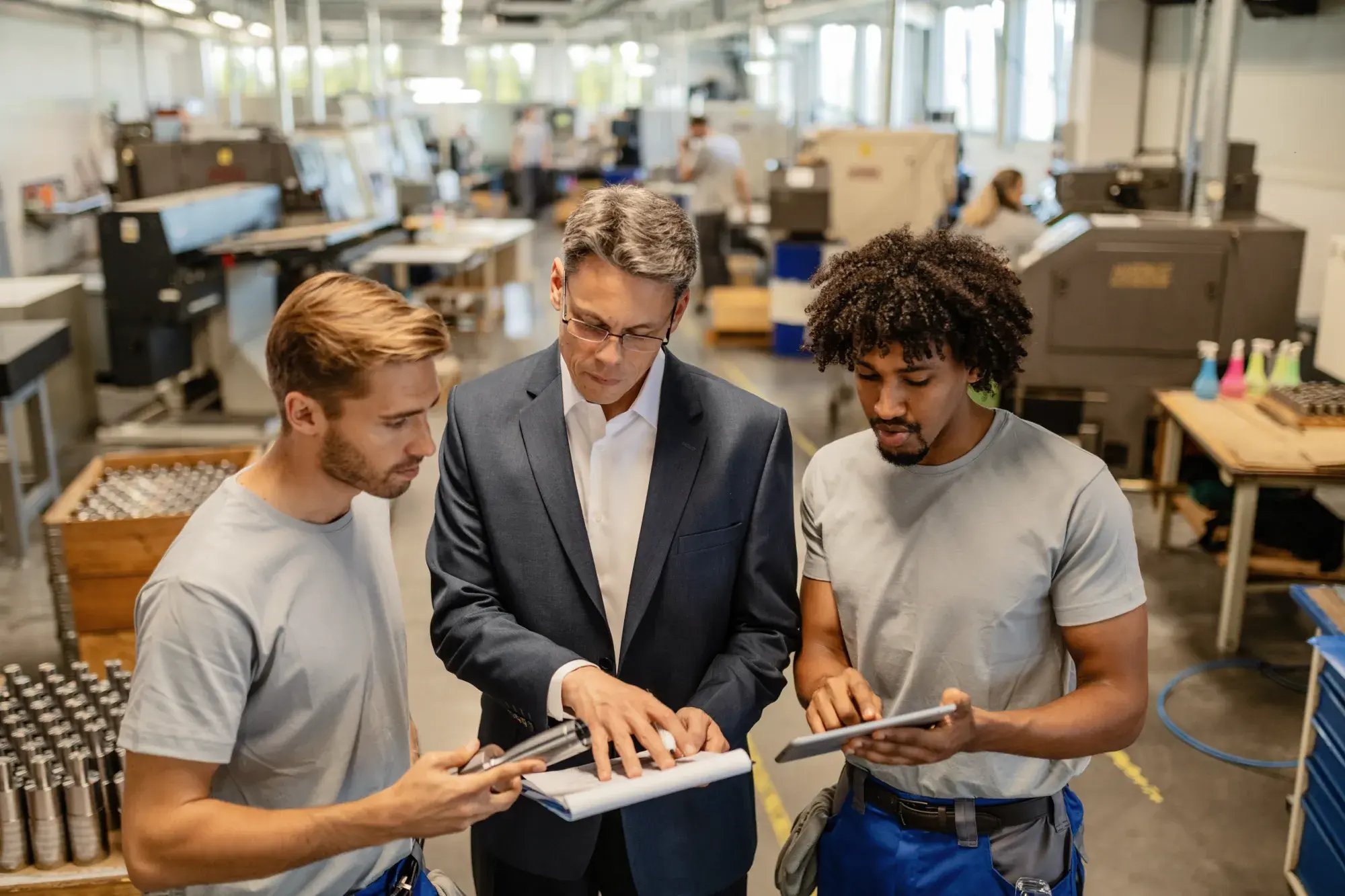 mid-adult-engineer-two-steel-workers-going-through-quality-reports-while-working-industrial-building-1